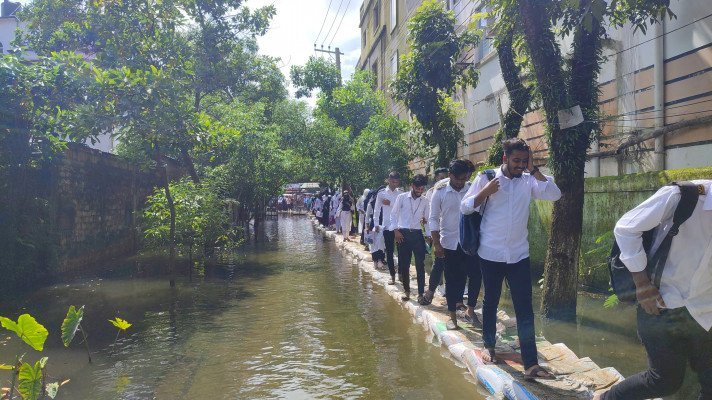 সিলেটে বন্যার পানি মাড়িয়েও কেন্দ্রে পৌছান পরিক্ষার্থীরা